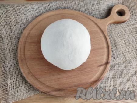 А затем переложить тесто на ровную поверхность, присыпанную 40 граммами муки, и вымесить его руками до гладкости. Тесто не должно липнуть к поверхности и рукам. Накрыть тесто для чебуреков миской и оставить на 7-10 минут.