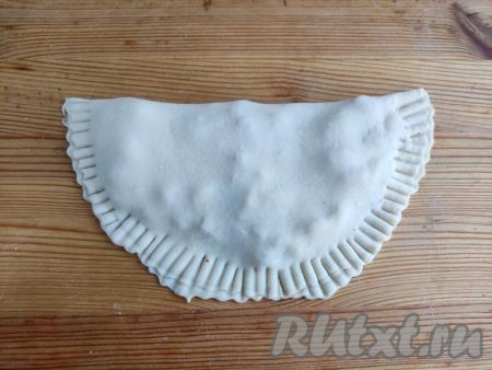 Прикрыть второй половиной круга, скрепить края чебурека вилкой. Также сформировать остальные 3 чебурека.