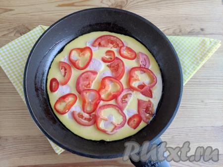 Болгарский перец очистить от внутренностей и семян, нарезать его колечками толщиной 5 мм и выложить рядом с помидорами. Накрыть сковороду крышкой, поставить на средний огонь и готовить ленивую пиццу в течение минут 8.