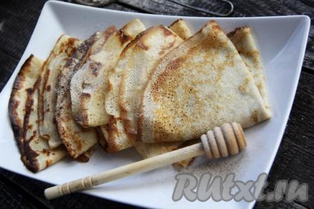 Складываем блинчики треугольниками и выкладываем на блюдо для подачи.