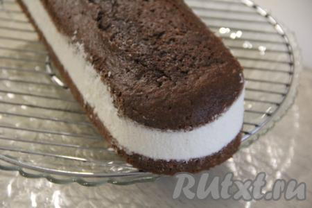 Накрыть крем верхним коржом и слегка прижать. Поставить домашний торт "Баунти" для стабилизации на ночь в холодильник. Затем аккуратно снять бортики формы и поместить торт на решётку.