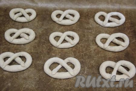 Противень застелить пергаментом (или тефлоновым ковриком) и выложить на него крендельки.