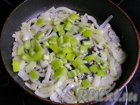 Кладём в сковородку кубики болгарского перца и жарим всё вместе, не забывая перемешивать, ещё 2-3 минуты.