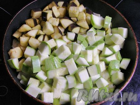 Выкладываем в сковородку с луком и перцем нарезанные баклажаны и кабачки, перемешиваем и жарим ещё минут 5, периодически помешивая.