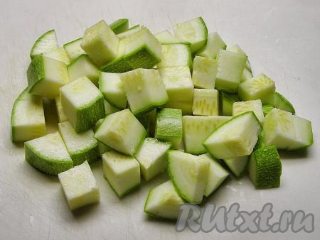 Молодой кабачок тоже хорошо моем, срезаем плодоножку (если у кабачка шкурка жестковата, её нужно срезать), а затем нарезаем кубиками, примерно, такого же размера, как нарезан и баклажан.