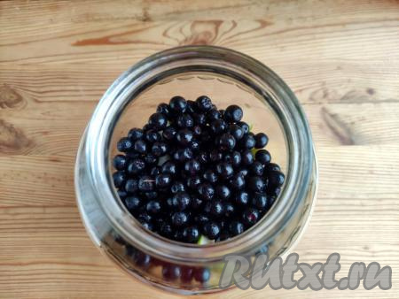 Всыпать подготовленные ягоды черноплодной рябины в банку с грушами.