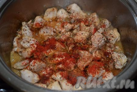 Затем, когда кусочки птицы побелеют, добавляем к ним соль, специи, паприку, чёрный молотый перец и перемешиваем.