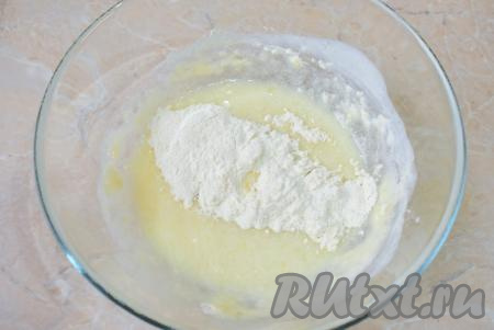Всыпьте соду, хорошо перемешайте, чтобы сода погасилась. После этого начните постепенно добавлять муку, перемешивая тесто столовой ложкой.