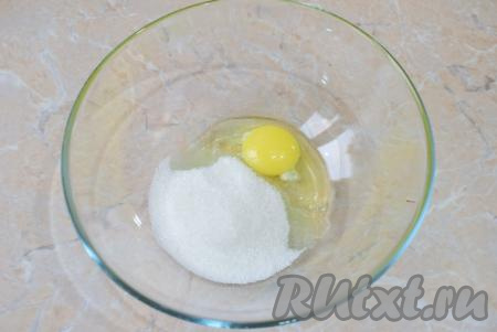 Вначале замесим тесто для оладий, для этого в достаточно глубокой миске слегка перемешайте венчиком яйцо с сахаром.