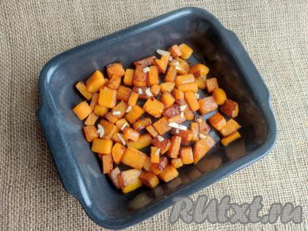 Посыпать тыкву очищенным и мелко нарезанным зубчиком чеснока.
