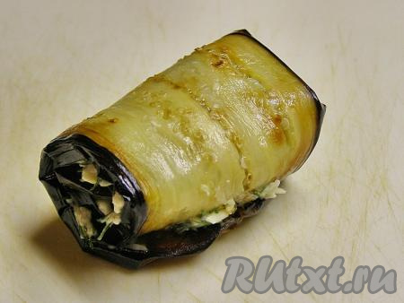 Сворачиваем пластину жареного баклажана с начинкой из сыра, укропа и чеснока в рулет. Так формируем все рулетики.&nbsp;Убираем приготовленные рулетики в холодильник, примерно, на 30 минут.