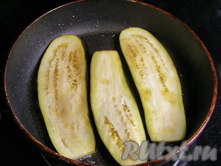 Через 10 минут ополаскиваем пластинки баклажанов прохладной водой и просушиваем на бумажном полотенце. В сковороде разогреваем растительное масло на сильном огне, уменьшаем огонь до среднего, выкладываем пластинки баклажанов и обжариваем их&nbsp;до золотисто-коричневого цвета с двух сторон.