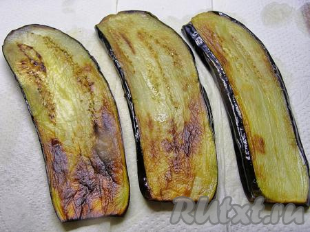 Обжаренные баклажаны перекладываем на бумажные полотенца, чтобы избавиться от лишнего масла, и оставляем остывать. Аналогично обжариваем оставшиеся пластины баклажанов.