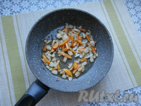 Очищенную луковицу нарезать достаточно мелко, половину очищенной морковки нарезать соломкой (или брусочками), выложить на сковороду с растительным маслом и на среднем огне обжарить, иногда перемешивая, до мягкости овощей (на это потребуется 4-5 минут).