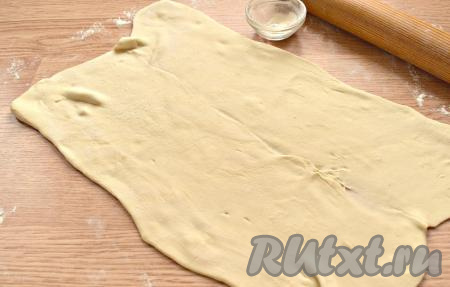 Пласт слоёного бездрожжевого теста выкладываем на поверхность стола, которую нужно посыпать немного мукой. Раскатываем пласт в четырёхугольник толщиной около 3 мм.