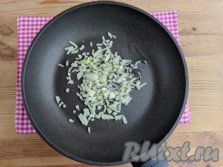 Растительное масло разогреть на сковороде, добавить очищенный, мелко нарезанный лук, обжарить его до лёгкого золотистого цвета на среднем огне, периодически помешивая (ориентировочно на это потребуется 3-5 минут).