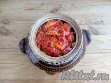 Сверху выложить тушёные овощи со сковороды, влить 120 мл горячей воды из чайника. Вода не должна&nbsp;быть выше половины уровня горшочка. Накрыть горшочек крышкой, отправить в разогретую духовку и готовить рыбу с овощами в течение 50 минут при температуре 190 градусов.