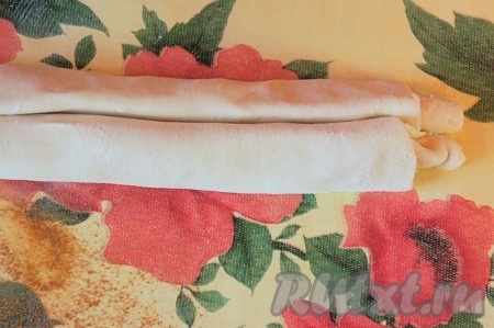 Намечаем середину раскатанного прямоугольника и, начиная с двух противоположных узких сторон, сворачиваем тесто к середине плотным рулетом. В результате сворачивания теста получится "двойной" рулет, как на фото (если вы раскатывали 2 пласта теста, у вас получатся соответственно 2 "двойных" рулета из двух прямоугольников теста).
