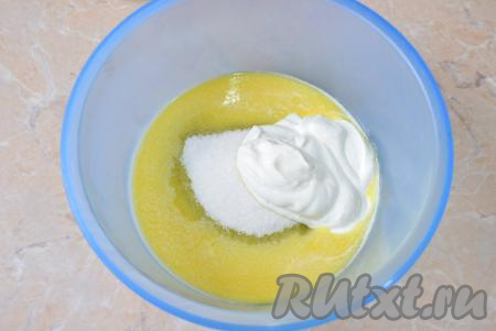 К негорячему растопленному маслу добавьте сахар и сметану, перемешайте до однородности венчиком (можно перемешать и миксером).