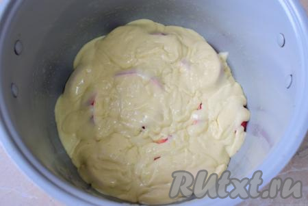 На яблоки, выложенные в чашу, вылейте половину теста, равномерно распределяя его по всей поверхности.