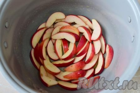 Яблоки помойте, удалите сердцевину и нарежьте ломтиками. Выложите половину нарезанных яблочных долек на дно чаши мультиварки.