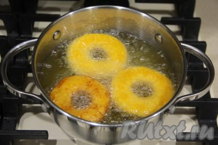 В кастрюле (или в сотейнике) хорошо разогреть достаточно большое количество растительного масла и аккуратно выложить пончики. Жарить тыквенные пончики до золотистого цвета на среднем огне.