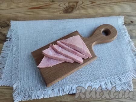 Колбасу нарезать на пять треугольных ломтиков толщиной около 4 мм.