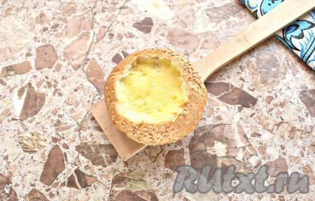 Булочку, фаршированную яйцом, сыром и колбасой, помещаем в форму для запекания (форму можно предварительно застелить пергаментом) и отправляем минут на 15-20 в духовку, разогретую до 180 градусов. Готовую яичницу достаём из духовки. Булочка после запекания сначала будет жёсткой, но буквально через пару минут стенки приобретут хрустящую структуру. Начинка внутри булочки получается сочной и сытной.