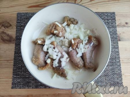 Затем к обжаренной икре добавить мелко нарезанные лук и чеснок, аккуратно перемешать, накрыть сковороду крышкой, убавить огонь до минимума. Томить икру с луком и чесноком, ещё&nbsp;около 5 минут, периодически перемешивая.