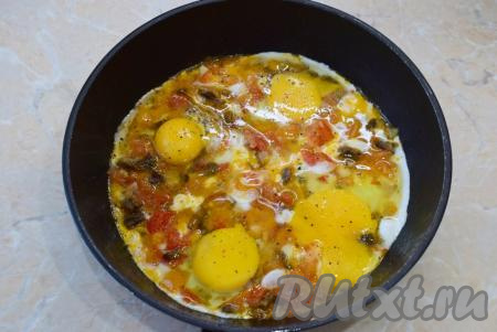 В сковороду к грибам и овощам вбейте сырые яйца. Посыпьте солью и специями. Готовьте ещё 3-5 минут (до готовности яиц). Большой огонь не делайте. Яйца должны полностью приготовиться, но не начать подгорать. Для ускорения процесса сковороду можно накрыть крышкой.