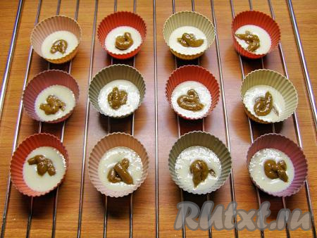 В середину каждой формочки с тестом кладём по 1 чайной ложке варёной сгущёнки (у меня сгущёнка была в мягкой упаковке, поэтому я выдавливала, примерно, по 2-2,5 см сгущёнки).