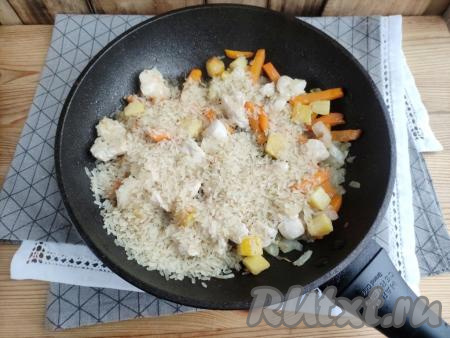 Рис тщательно промыть, лишней жидкости дать стечь. Когда кусочки филе станут белыми, выложить рис.