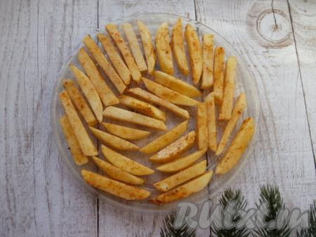 На блюдо для микроволновки выложить брусочки картофеля в один слой.