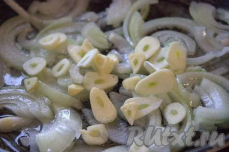 Чеснок очистить и нарезать на тонкие дольки. Добавить в сковороду к луку дольки чеснока, обжарить, тщательно помешивая, примерно, 1 минуту.