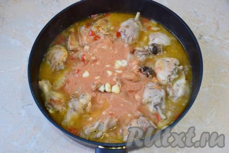 После того как курица протушится 15-20 минут, влейте в сковороду томатный соус, перемешайте. Если хотите, чтобы было больше соуса, то можно подлить больше воды. Добавьте нарезанный чеснок. По вкусу немного подсолите и добавьте специй.