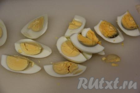 Почистить варёные яйца и нарезать на крупные дольки.