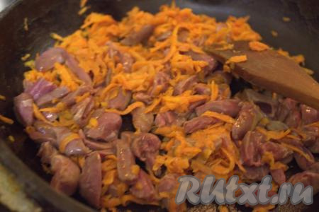 Затем к моркови в сковороду добавить куриные сердечки, хорошо перемешать и обжаривать, не забывая помешивать, на среднем огне минут 10.