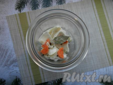 В чистую, сухую двухлитровую банку складывать капусту слоями, пересыпая её горошинами перца, кориандром, кусочками моркови и чеснока, добавить лавровый лист.