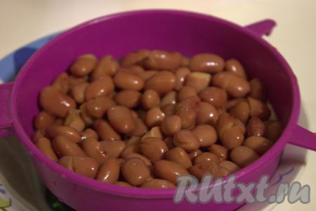 Красную консервированную фасоль переложить из банки в сито. Промыть фасоль водой и оставить на несколько минут в сите, чтобы стекла лишняя жидкость.