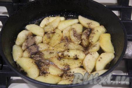 По истечении 5 минут яблоки на сковороде карамелизируются, всыпать к ним корицу, аккуратно перемешать и разровнять слой яблок.