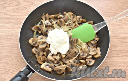 Добавляем к шампиньонам сметану. Убавляем нагрев плиты до среднего.