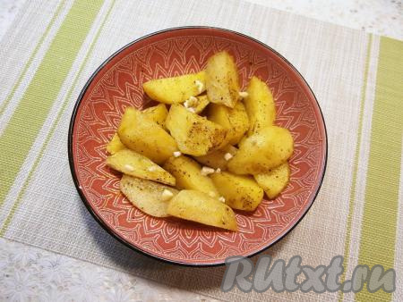 Отправить посуду с дольками картошки в микроволновку, накрыть крышкой с отверстием для выхода пара. Готовить при мощности 750 Ватт 10 минут, после чего добавить мелко нарезанный чеснок, картофель перемешать и готовить ещё 10 минут.&nbsp;