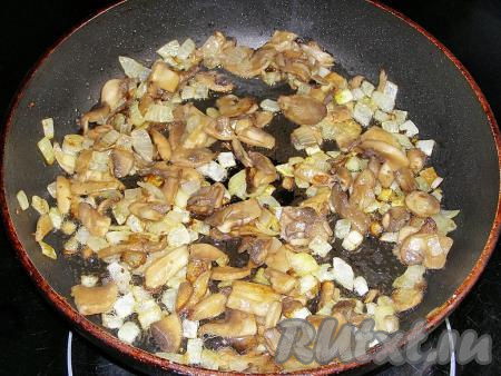 В сковородке слегка разогреваем растительное масло и выкладываем в неё лук. Обжариваем, помешивая, 2-3 минуты на среднем огне.&nbsp;Затем добавляем нарезанные грибы и жарим, иногда перемешивая, минут 10-15 (пока из грибочков не испарится почти вся влага). Убираем сковороду с огня.