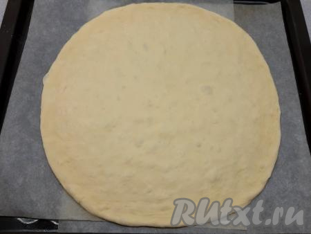 Противень застилаю бумагой для выпечки, переношу одну часть мягкого, воздушного теста, затем пальцами растягиваю в круглый пласт диаметром 30 см, припыляя руки мукой.