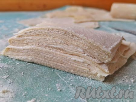 Сложить подсохшие пластинки теста друг на друга, разрезать пополам, снова сложить друг на друга.