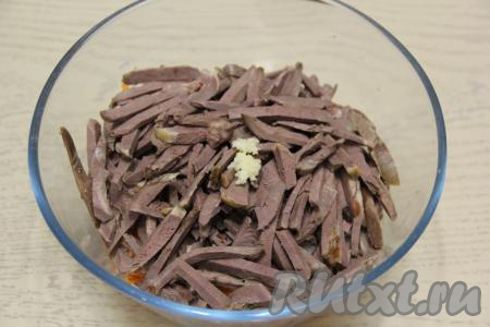 Сердце вынуть из бульона и нарезать на тонкие брусочки, переложить в миску с овощами. Сюда же выложить пропущенный через пресс чеснок.