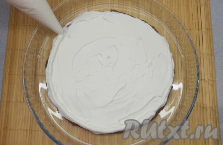 Теперь собираю торт. Первый корж выкладываю на тарелку для подачи, покрываю его слоем крема и при помощи кондитерского мешка отсаживаю по кругу небольшой бортик из крема, который и будет держать клубничный конфи.