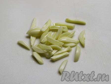 Очищенные от шелухи зубчики чеснока нарезаем брусочками.