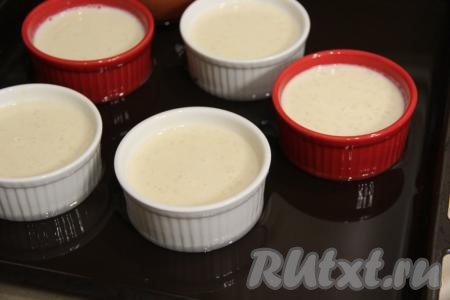 Разложить массу по порционным формочкам (я разлила по 6 формочкам) и поставить на противень. Влить на противень воду, чтобы она покрывала формочки, примерно, на 1 см. 