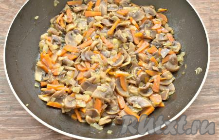 Жарим 2 минуты на среднем огне, затем убавляем нагрев плиты и тушим грибы в выделившемся соке 8 минут под крышкой, иногда помешиваем. Снимаем с огня и оставляем шампиньоны с морковкой и луком немного остыть.